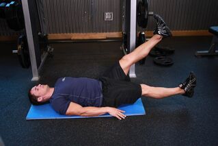 Mann mat Prostatitis mécht eng Übung am Fitnessstudio